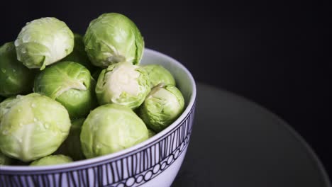 pan right of fresh brussel sprouts rotating on black background