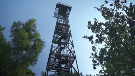 Skyward-shot-of-a-tall-observation-tower-which-gives-visitors-a-bird's-eye-view-of-the-surrounding-landscape,-Kalmthoutse-Heid,-Belgium