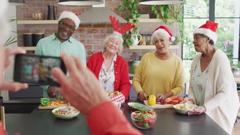 Gruppe-Glücklicher,-Vielfältiger-älterer-Freunde,-Die-Zur-Weihnachtszeit-Gemeinsam-Kochen-Und-Selfies-Machen