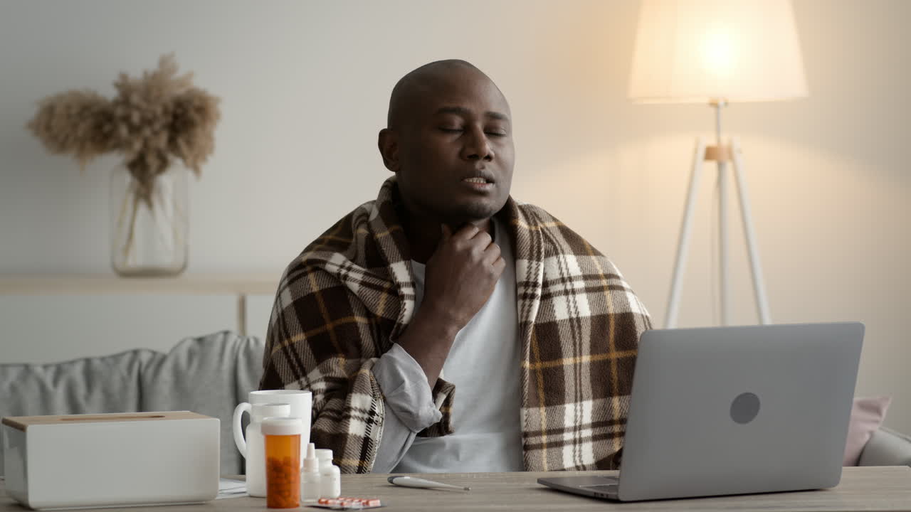 Man Having a Video Call with Doctor for a Sore Throat