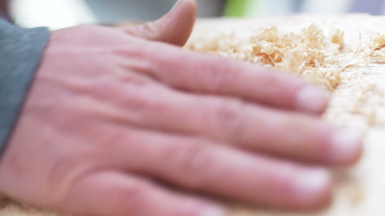 diy 배경 작업장에서 나무 부스러기를 뿌리는 만족스러운 남자