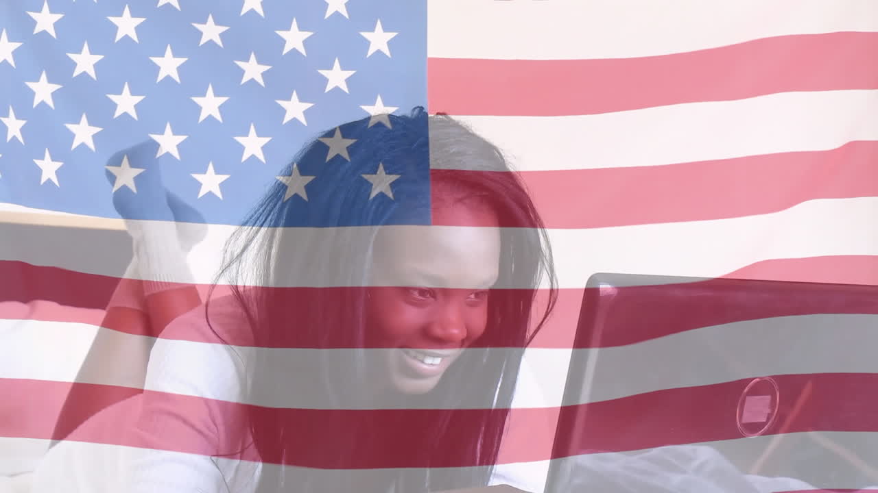 animación de la bandera estadounidense ondeando sobre una feliz mujer afroamericana acostada en la cama
