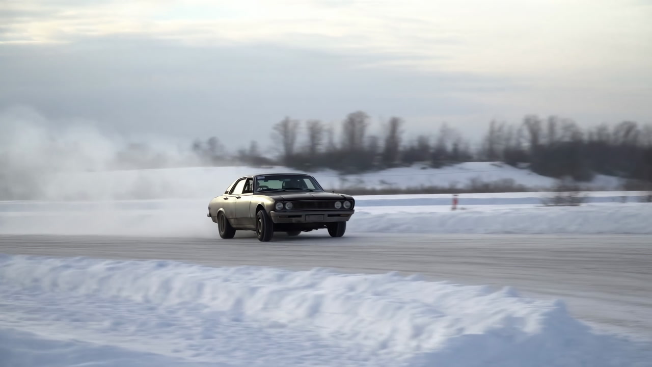 Classic Car Drifting On Snowy Track, Vintage Muscle Car Slides Through Icy Curve Sending Plume Of Snow, Orange