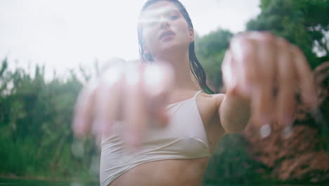 attractive girl waving hands smoothly in emerald lagoon portrait. lady posing