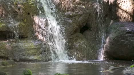 hermosa cascada de montaña cayendo sobre rocas cubiertas de musgo en el bosque en suiza