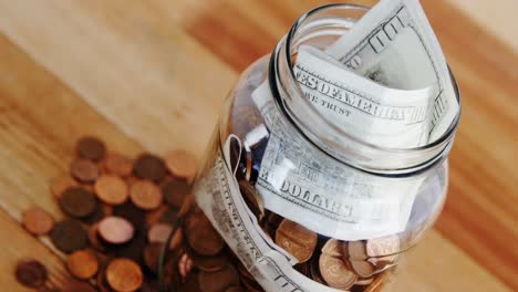 close-up of coins and currency notes in bottle