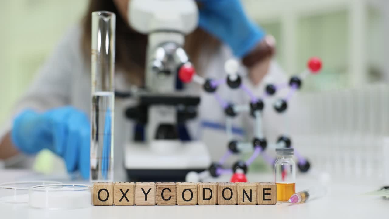 Researcher analyzes oxycodone sample with molecule model
