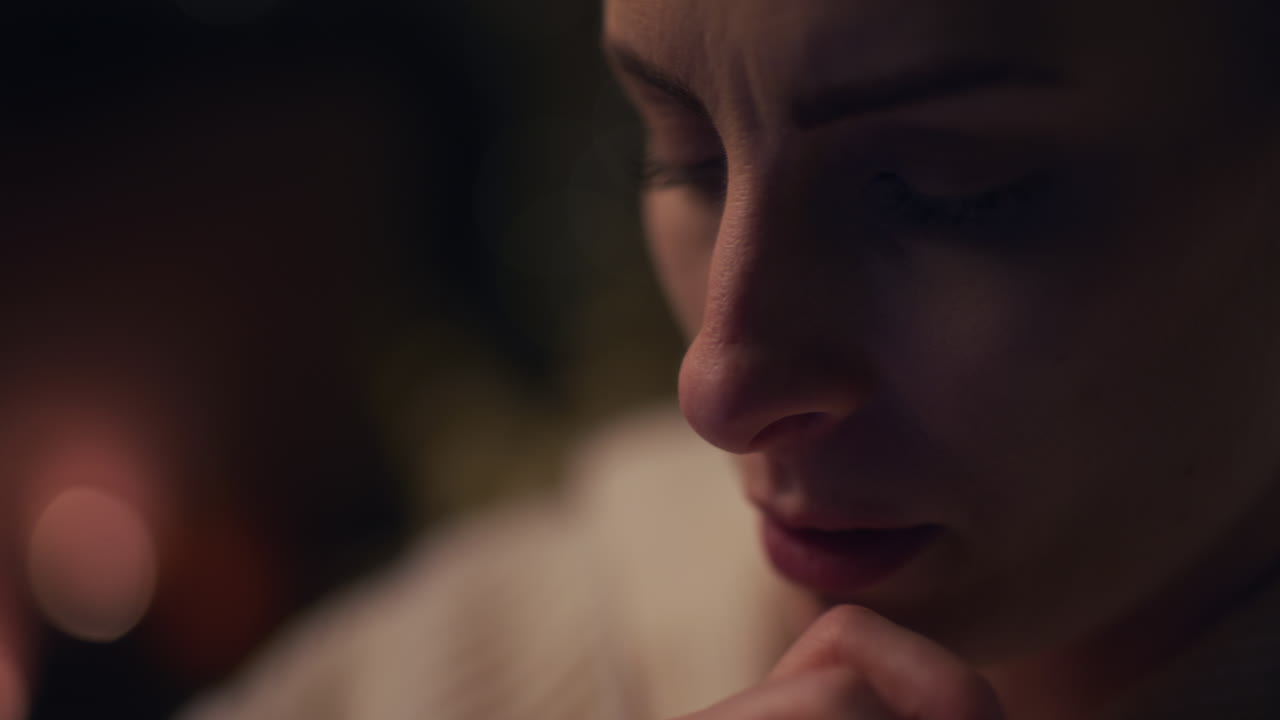 밤에 지체된 돈을 처리하는 동안 여성이 노트북을 긴장해서 닫습니다.