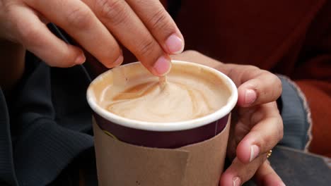 a close-up of a hand holding a coffee cup