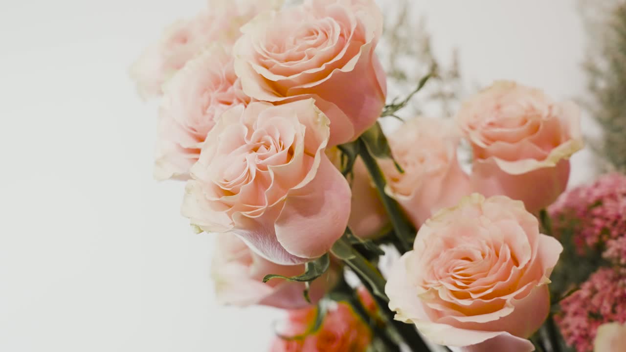 una floristería ajustando rosas rosadas para un ramo