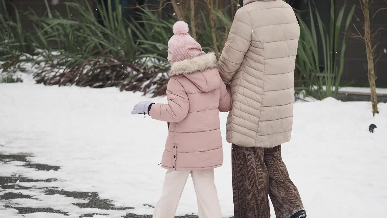 Mother and Daughter Walking in the Snow
