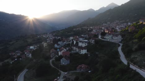 Pueblo-De-Montaña-De-Tetovo-En-Las-Estribaciones-De-La-Montaña-Sar-Mientras-El-Sol-Está-Justo-Encima-De-Las-Siluetas-De-Las-Montañas-En-El-Fondo