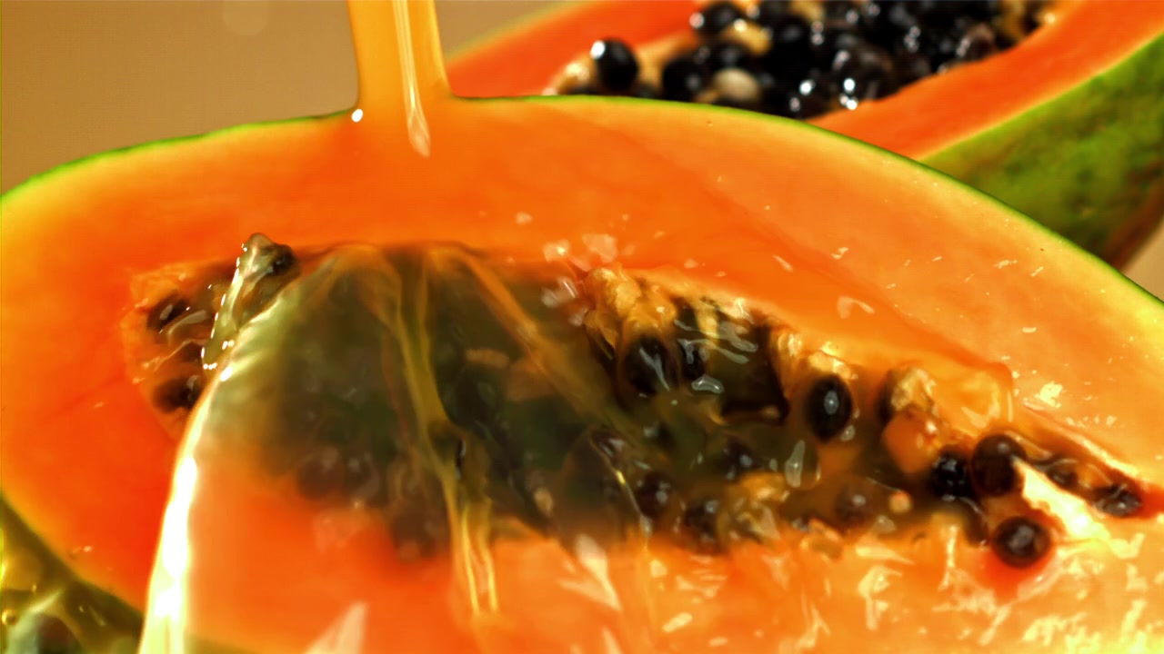 Papayajuice helles over fersk halvert papaya.