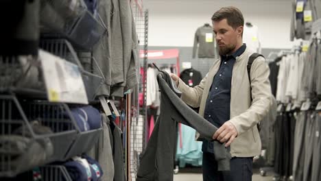hombre comprando ropa en una tienda de ropa deportiva