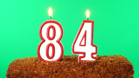cake with the number 84 lighted candle. chroma key. green screen. isolated