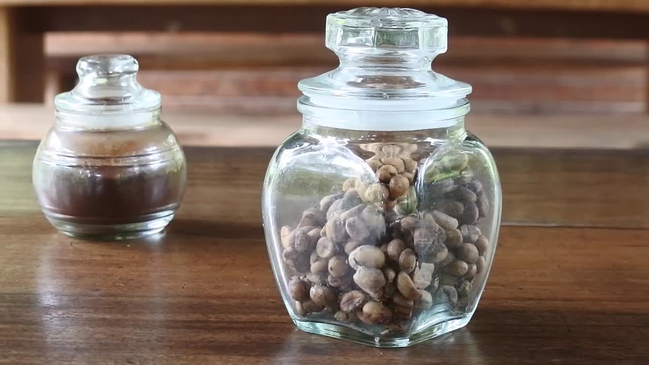 나무 테이블 위 에 있는 유리 항아리 에 있는 정통 한 인도네시아 루와크 커피 의 팬  ⁇