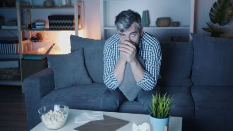 man crying on the couch