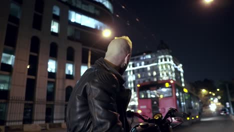 low angle view of a brutal rider sitting on motocycle on the city night street