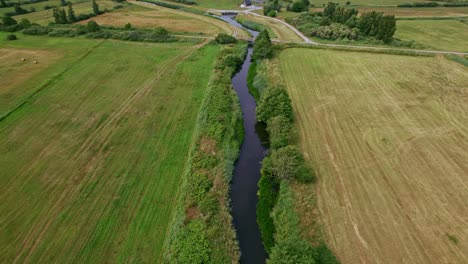 Flying-over-a-river-to-reveal-a-building-and-a-bridge-in-Polish-nature-reserve-"Beka"