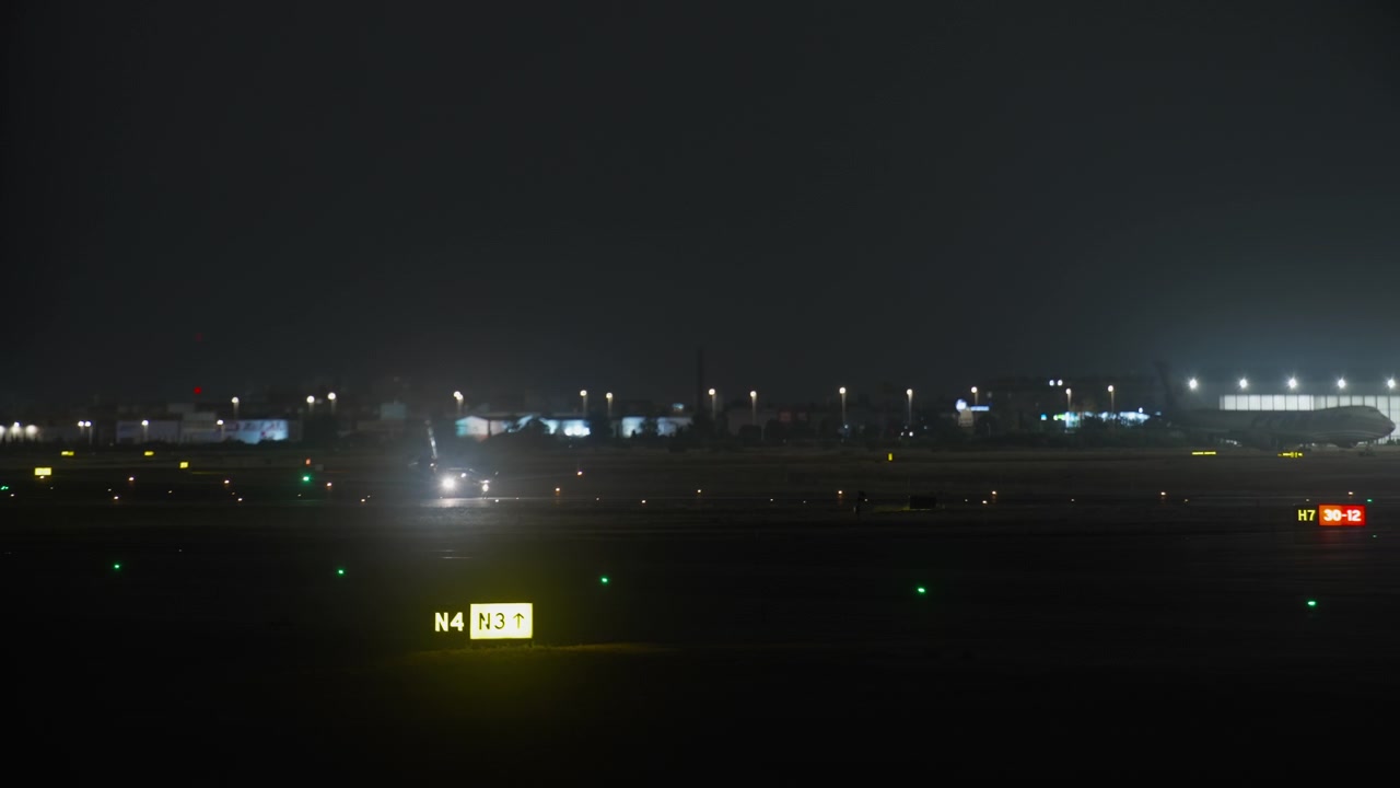 Aereo in rullaggio sulla pista dell'aeroporto di notte