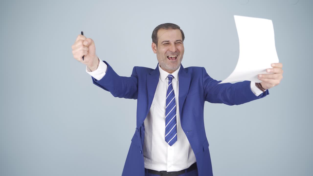 el hombre de negocios mira el documento en su mano y se alegra.