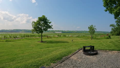 Time-lapse-at-campfire-ring,-lily-pads,-and-a-barge-navigating-on-the-Mississippi-River-at-Lock-and-Dam-No