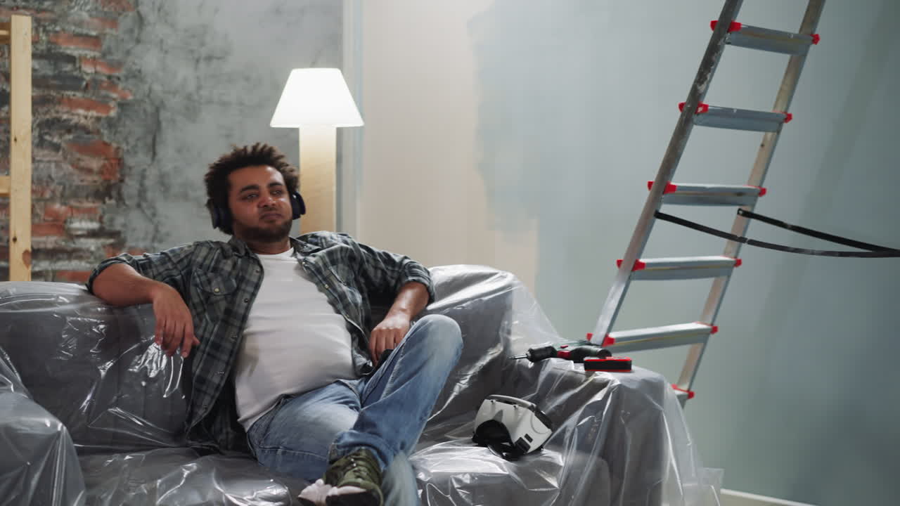 reparador afroamericano con auriculares aplaudiendo en las rodillas