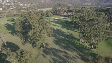 Vuelo-A-Través-De-Los-árboles-De-La-Calle-Hasta-El-Hoyo-15-En-El-Campo-De-Golf-De-Knysna