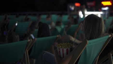 Frau-Sitzt-Auf-Einer-Bequemen-Liege-Und-Isst-Popcorn-Im-Sommerkino