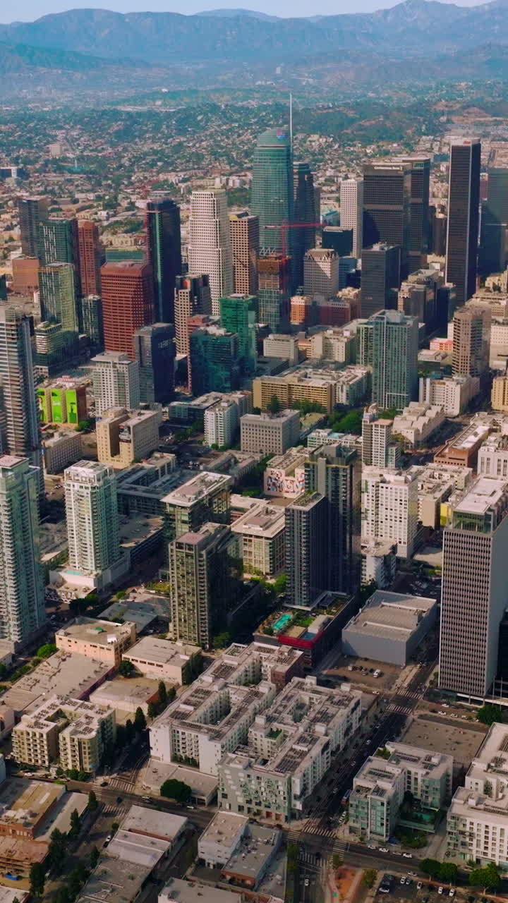 Skyscrapers and multi-storied buildings of financial Los Angeles downtown. Stunning city panorama at the backdrop of mountains. Vertical video