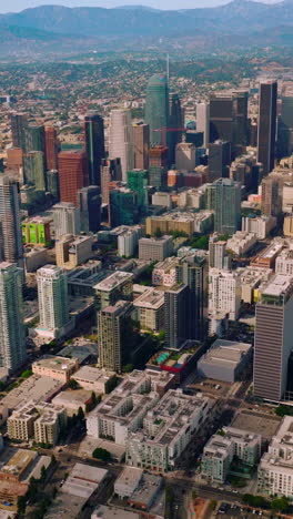 skyscrapers and multi-storied buildings of financial los angeles downtown. stunning city panorama at the backdrop of mountains. vertical video