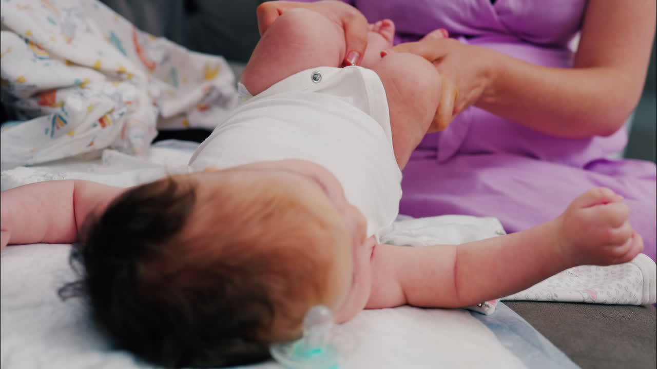 Primo piano di una madre che fa esercizi di mobilità con il suo bambino