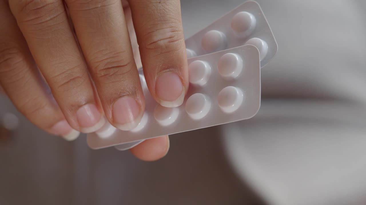 Close-up of a hand holding blister packs of pills
