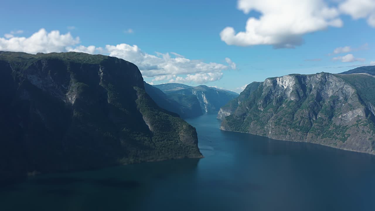 Penerbangan maju kecepatan tinggi dari udara di atas Fyord Aurlandsfjord di antara puncak-puncak gunung