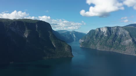 Aurlandsfjord-Vuelo-Aéreo-De-Alta-Velocidad-Hacia-Adelante-Sobre-El-Fiordo-Entre-Las-Montañas-Se-Asoma