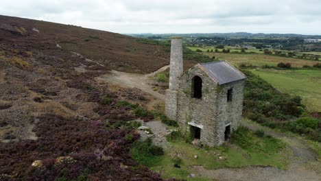 Parys-mountain-abandoned-brick-chimney-copper-mining-mill-stone-ruin-aerial-view-slow-reverse-right