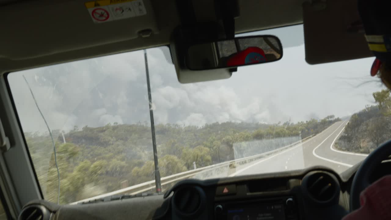 Driving passenger point of view, Australia road during vegetation wildfire