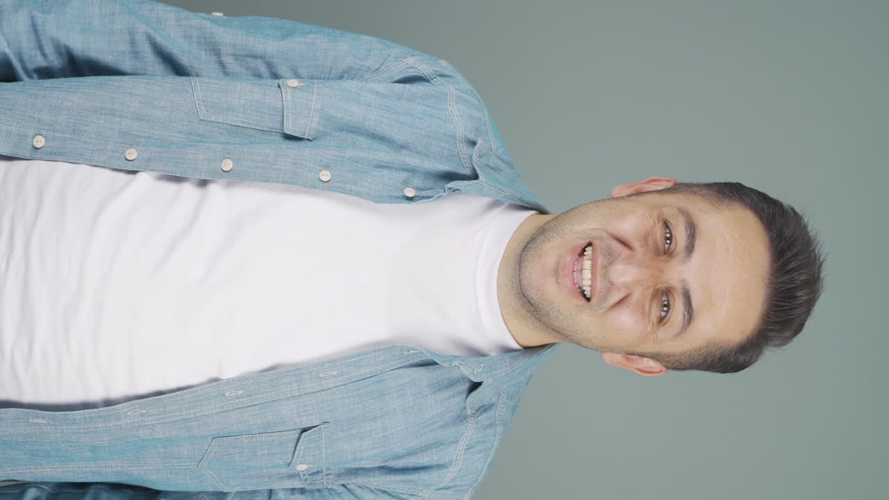 video vertical de un hombre feliz saludando a la cámara.