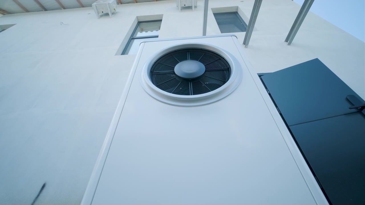 Moderne varmepumpe installeret på husets ydervæg