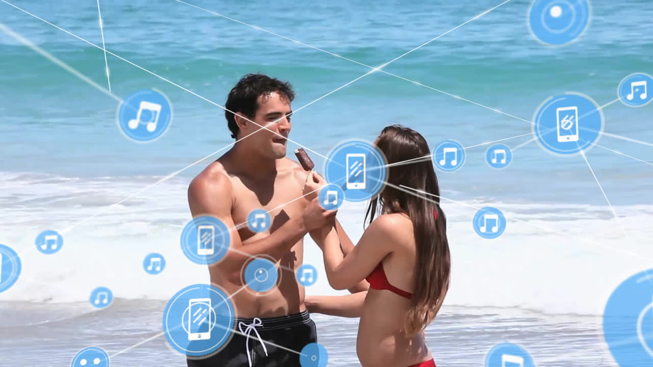 animación de redes de conexiones con iconos de dispositivos sobre pareja caucásica con helado en la playa