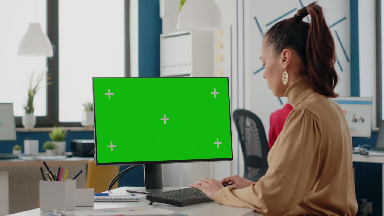 Business woman looking at computer with green screen