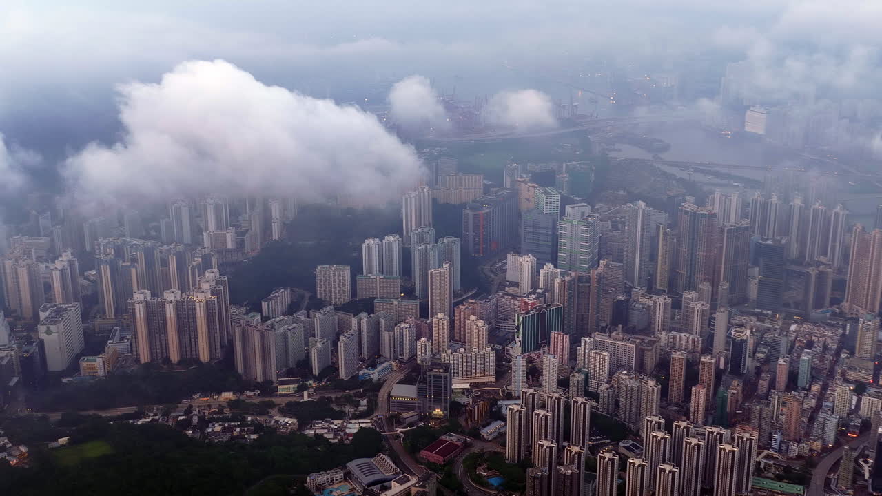 Cinematic aerial view of the Hong Kong skyline in morning light with cloud cover, showcasing the metropolitan city as a symbol of global finance, modern architecture, travel, and business