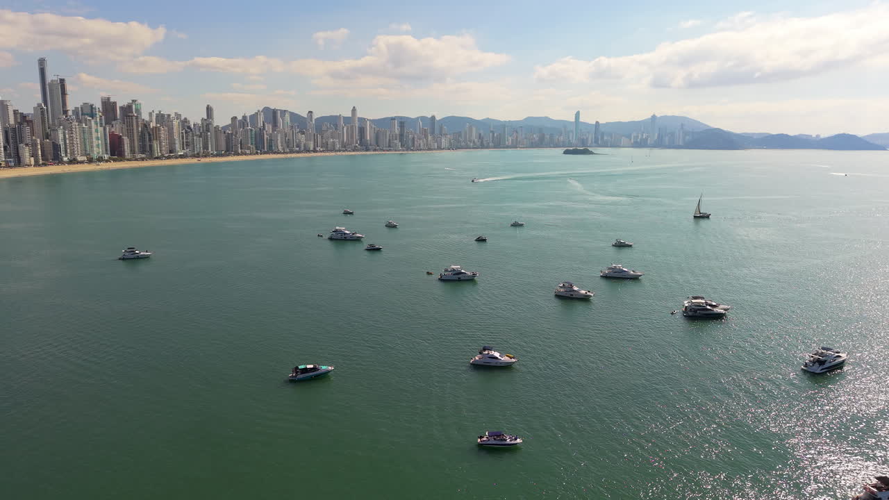Luxury yachts float on the water as Balneário Camboriú’s beachside skyscrapers rise behind