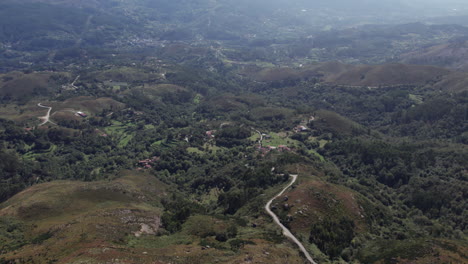 Camino-Solitario-Revelado-En-Medio-De-La-Nada-Rodeado-De-Colinas,-Granjas-Y-Montañas