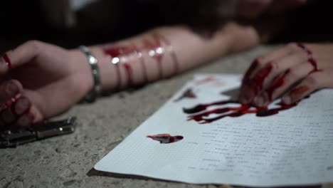 Corpse-on-the-floor-with-veins-cut,-knife-and-bloody-hand