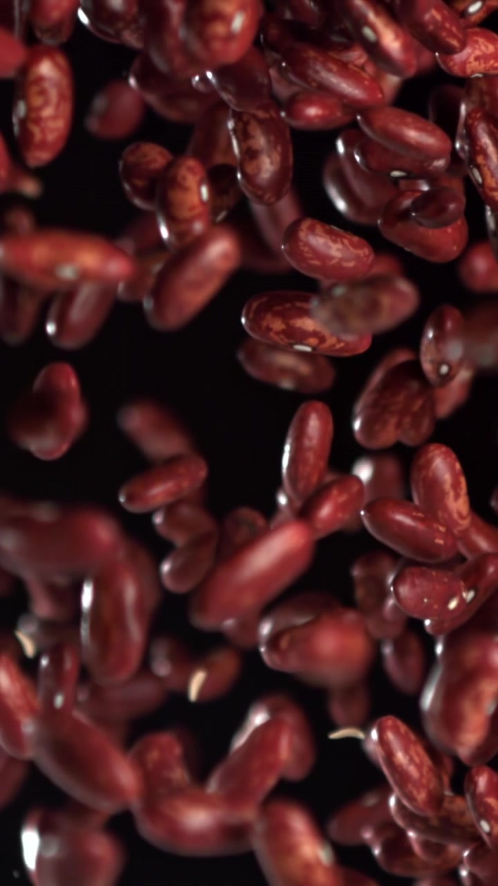 Red Kidney Beans Falling in Slow Motion on Black Background