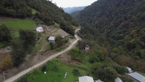 el avión sigue el camino de tierra fuera de la aldea en la empinada ladera de la montaña del bosque
