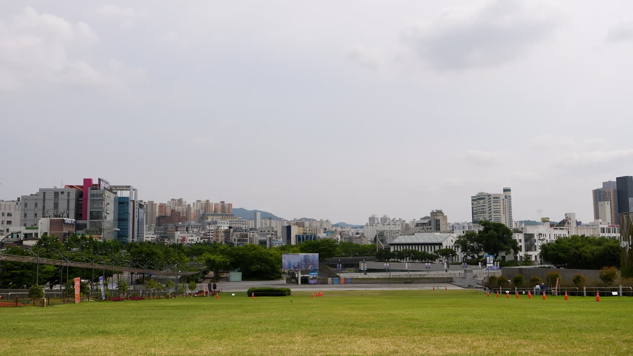 흐린 날 배경에 있는 잔디밭 공원과 광주시의 스카이라인의 정적 와이드 샷 - 한국, 아시아