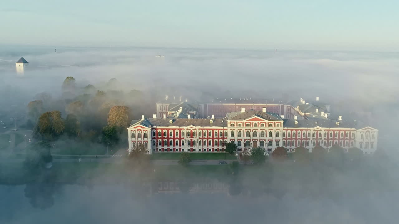 toma aérea revelada del majestuoso edificio del castillo del palacio de jelgava entre un denso día de niebla en letonia