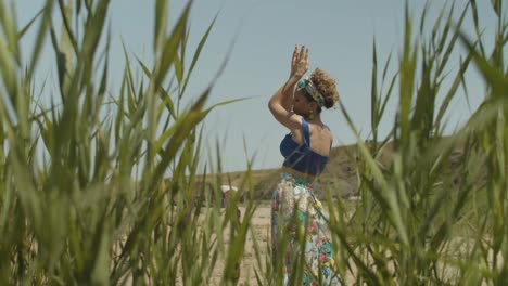 Enfoque-En-Rack-Entre-Juncos-De-Una-Mujer-Europea-Feliz-Bailando-Con-Las-Manos-En-El-Aire